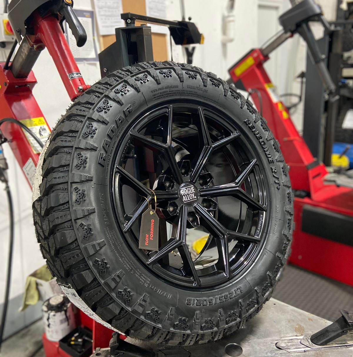 Gloss black flow-formed wheel on the tyre machine, tag still on