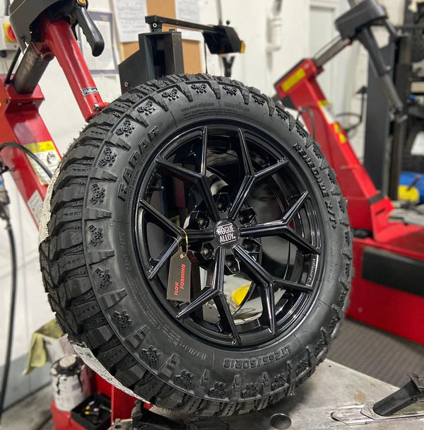 Gloss black flow-formed wheel on the tyre machine, tag still on