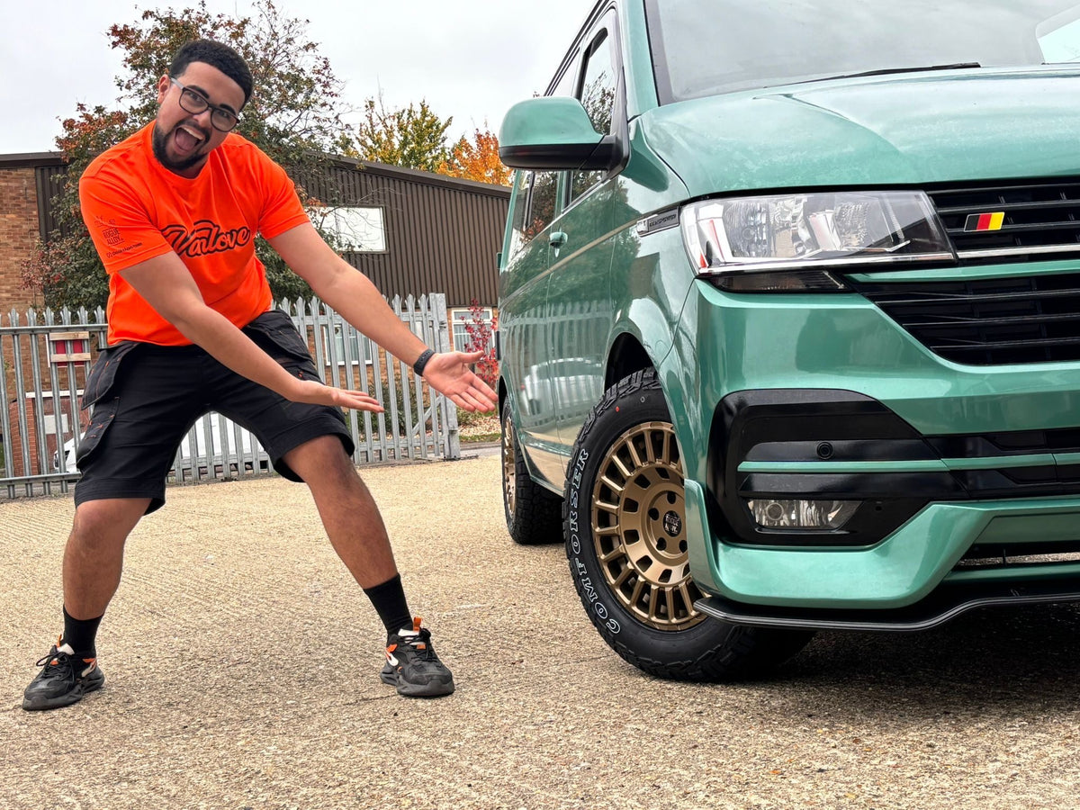 A Rogue team member beside a green Volkswagen Transporter on gold Rogue wheels